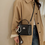 mini handbag in elegantly curved design with playful charm