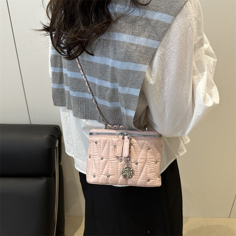 mini handbag with elegant quilting and chain pendant