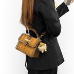 Women’s mini handbag with decorative braided pattern and playful charm