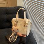 mini handbag with textured design and fluffy pendant