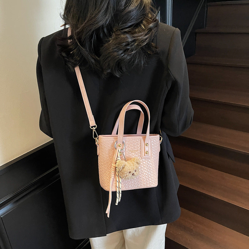 mini handbag with textured design and fluffy pendant