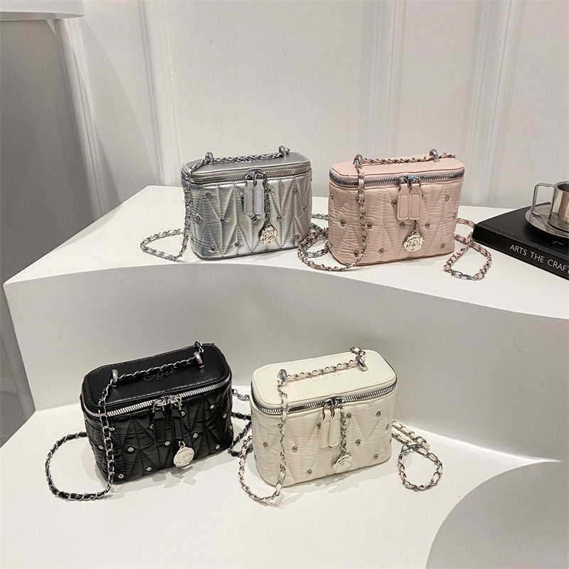 mini handbag with elegant quilting and chain pendant