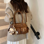 Elegant Handbag with Playful Charms and Multiple Compartments