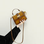 Women’s mini handbag with decorative braided pattern and playful charm