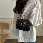 mini handbag with decorative quilting and playful cat motif