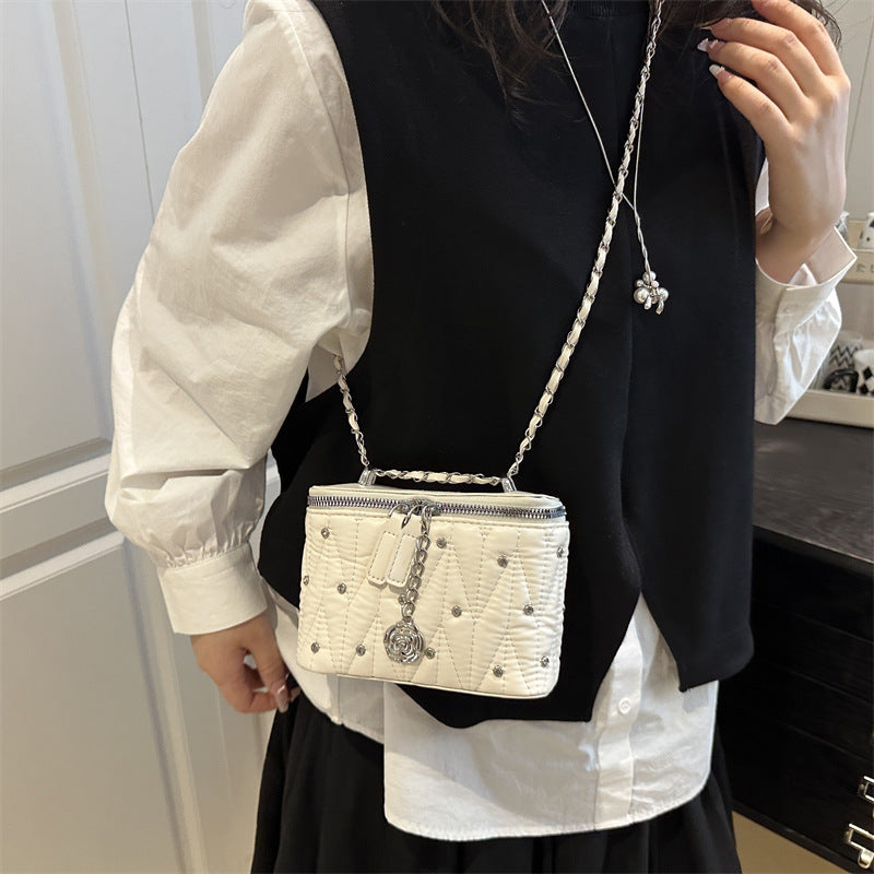 mini handbag with elegant quilting and chain pendant